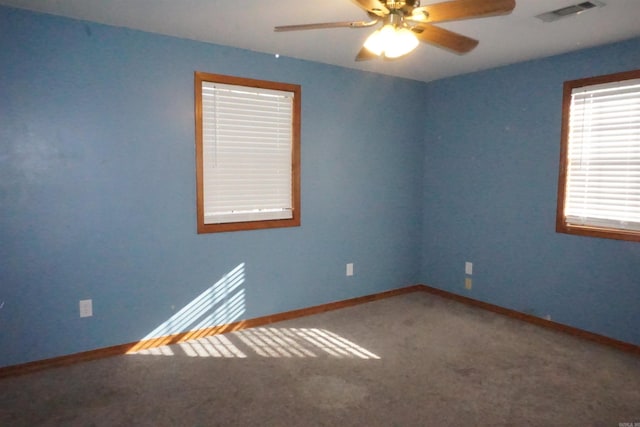 carpeted spare room featuring ceiling fan