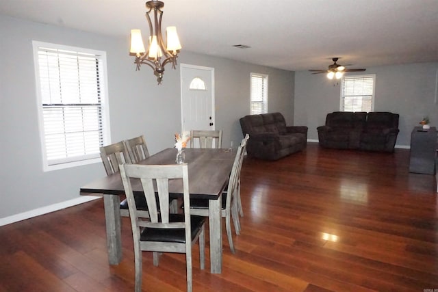 dining area featuring ceiling fan with notable chandelier and dark hardwood / wood-style floors