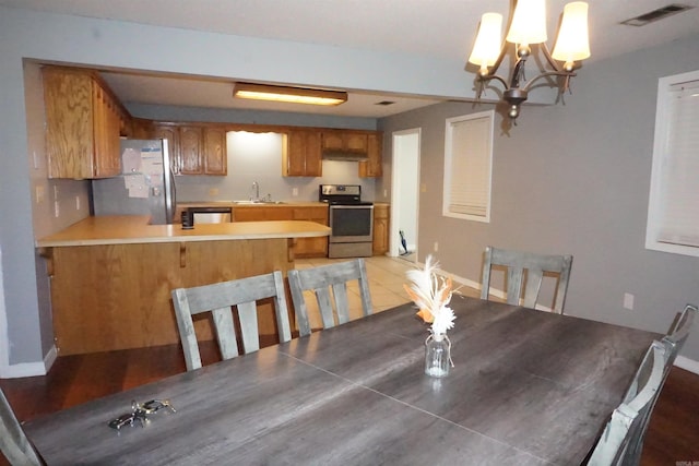 tiled dining area featuring sink and an inviting chandelier