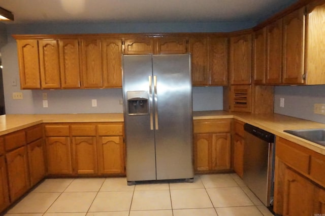 kitchen featuring appliances with stainless steel finishes, sink, and light tile patterned floors