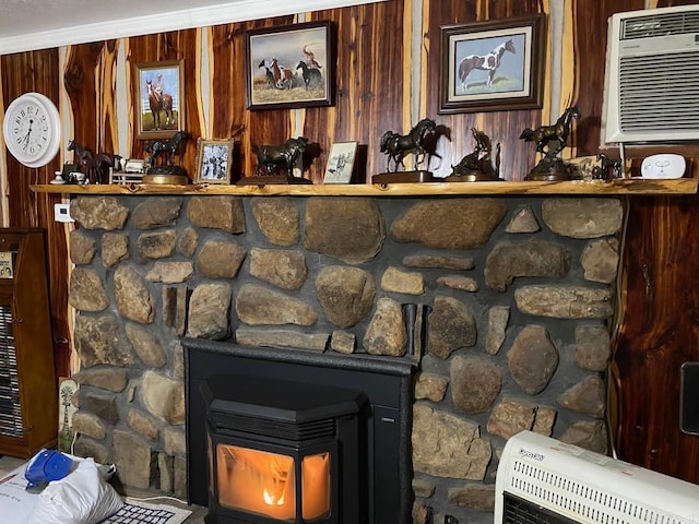 interior details with heating unit, a wall mounted air conditioner, ornamental molding, wood walls, and a wood stove