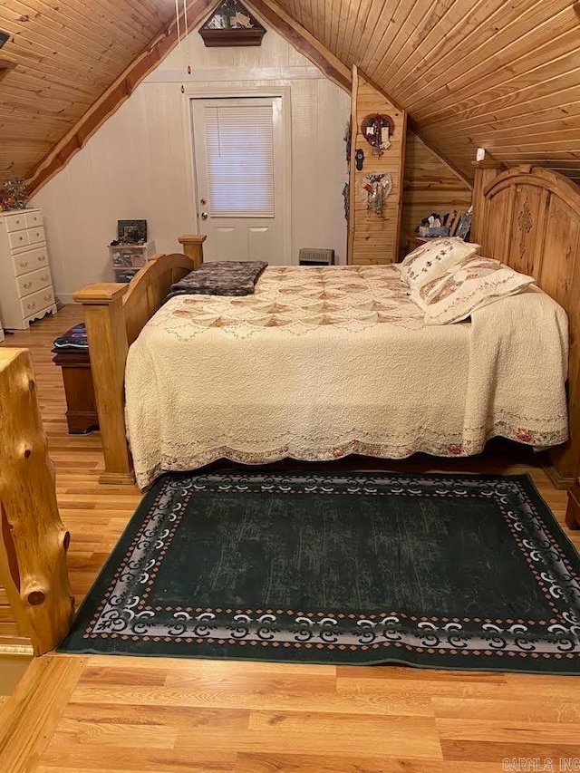 bedroom featuring lofted ceiling, hardwood / wood-style floors, wood ceiling, and wood walls