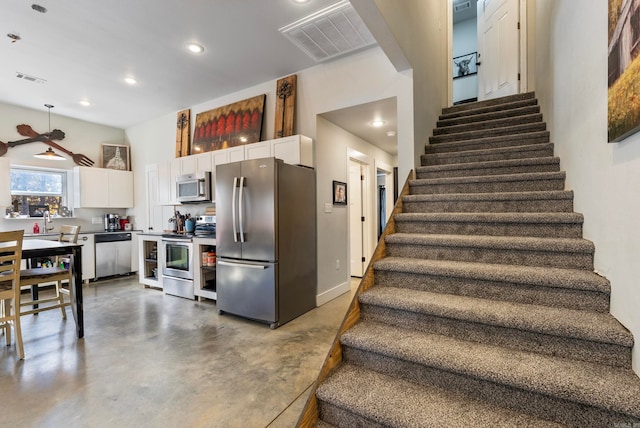 stairway featuring concrete floors and ceiling fan