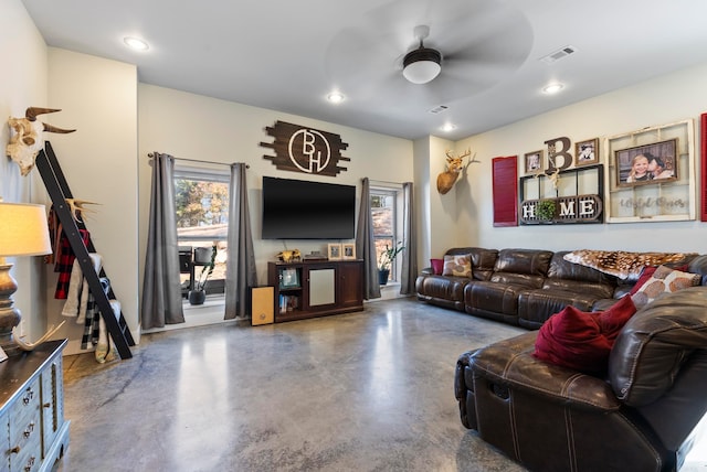 living room featuring ceiling fan and concrete flooring