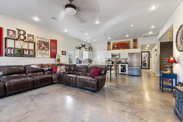 living room with concrete floors and ceiling fan