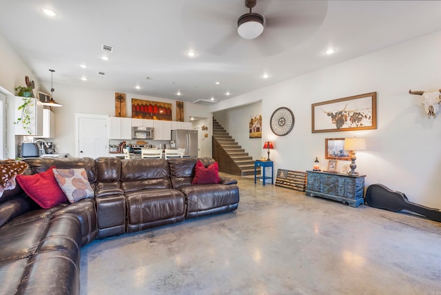 living room featuring ceiling fan and concrete flooring