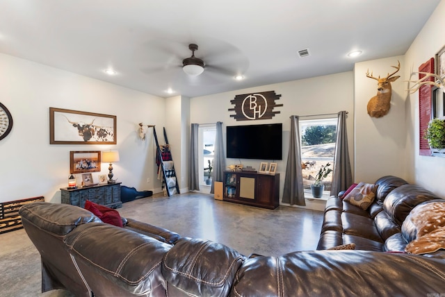 living room featuring ceiling fan and concrete flooring