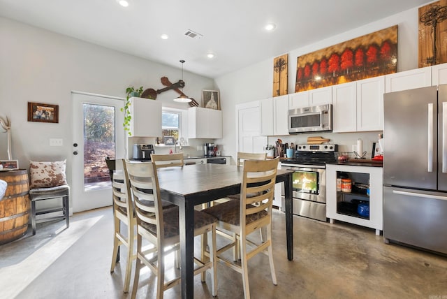 kitchen with white cabinetry, stainless steel appliances, sink, and pendant lighting