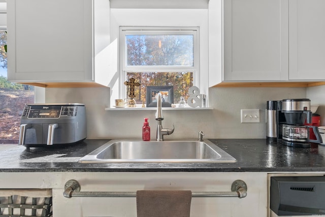 kitchen featuring white cabinetry and sink