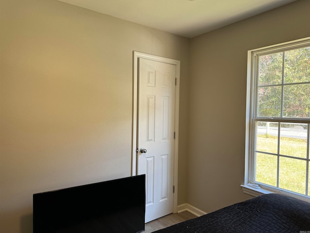 unfurnished bedroom featuring hardwood / wood-style flooring and multiple windows