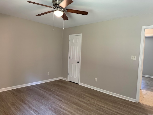 spare room featuring dark wood-type flooring and ceiling fan