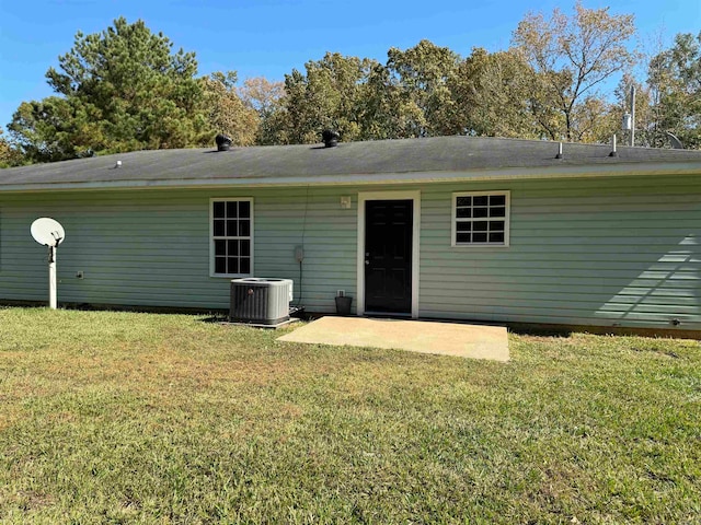 rear view of property featuring a yard, a patio, and central AC unit