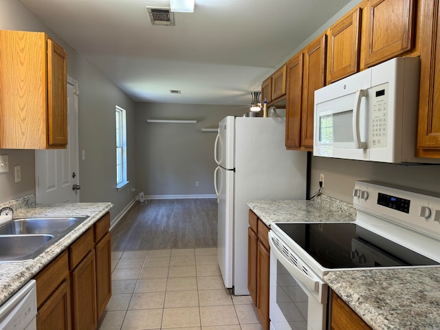 kitchen featuring sink, light tile patterned floors, and white appliances