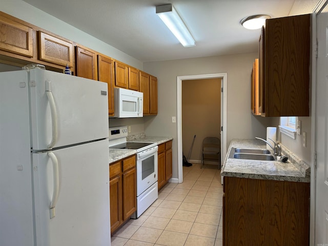 kitchen with light tile patterned flooring, sink, and white appliances