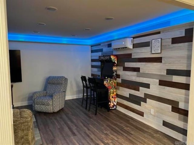 living area featuring a wall mounted air conditioner and hardwood / wood-style floors