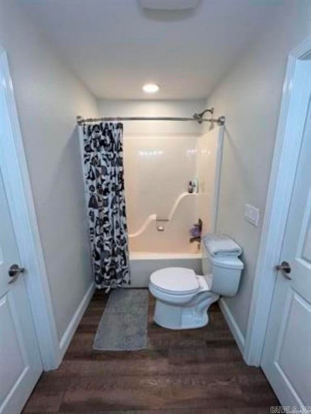 bathroom with shower / bath combo, hardwood / wood-style flooring, and toilet