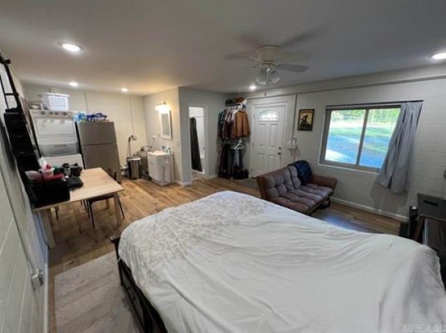 bedroom with light hardwood / wood-style floors, a closet, stainless steel fridge, and ceiling fan