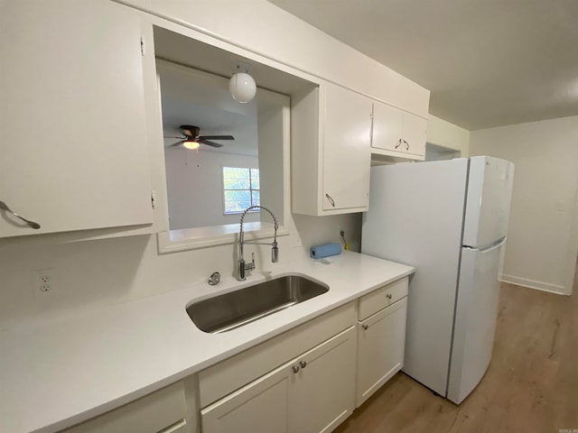 kitchen featuring sink, white cabinetry, and white refrigerator