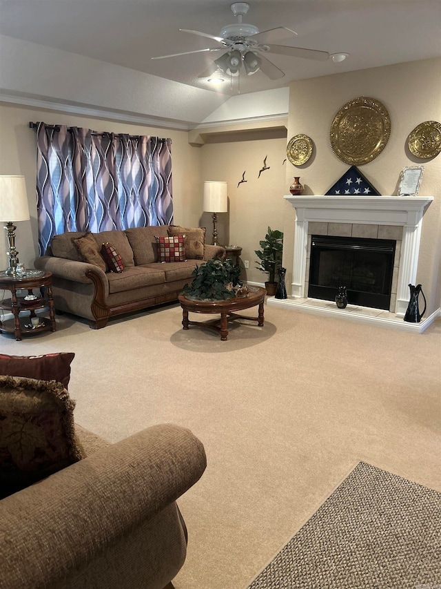 living room with a tile fireplace, carpet, and ceiling fan