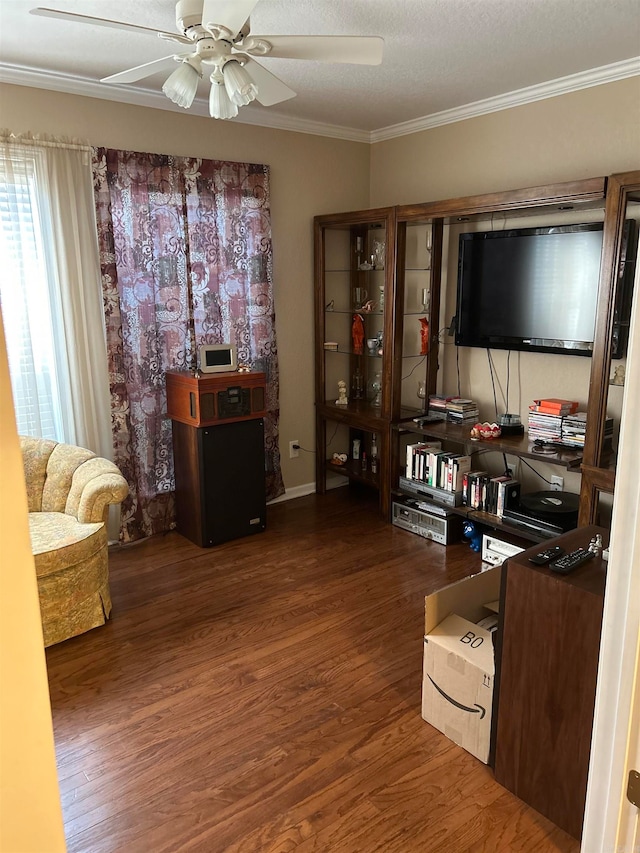 living room with dark wood-type flooring, ceiling fan, crown molding, and a textured ceiling