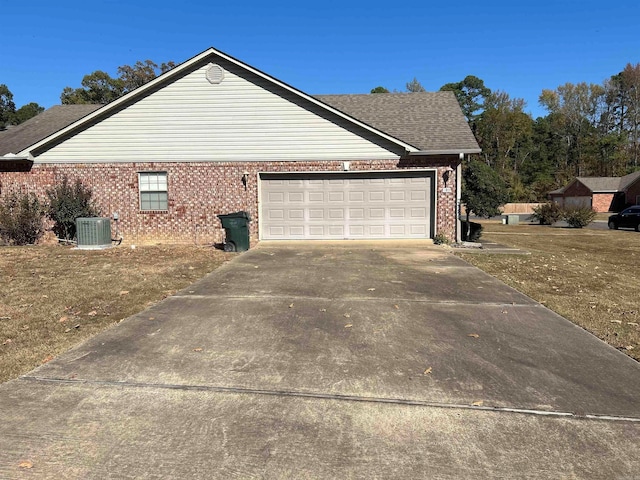 view of side of home with central AC, a garage, and a lawn