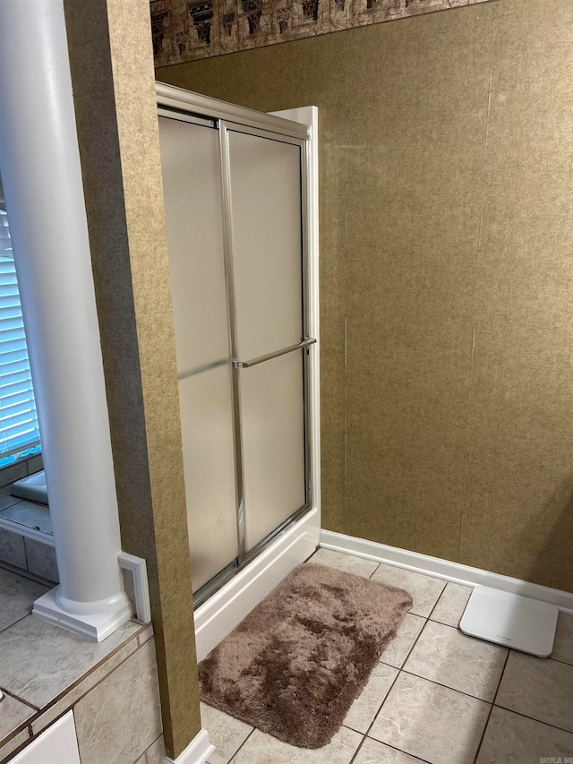 bathroom featuring a shower with shower door, ornate columns, and tile patterned flooring