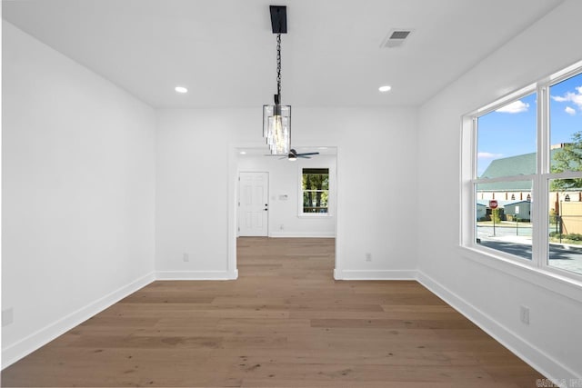 unfurnished dining area featuring ceiling fan and hardwood / wood-style floors