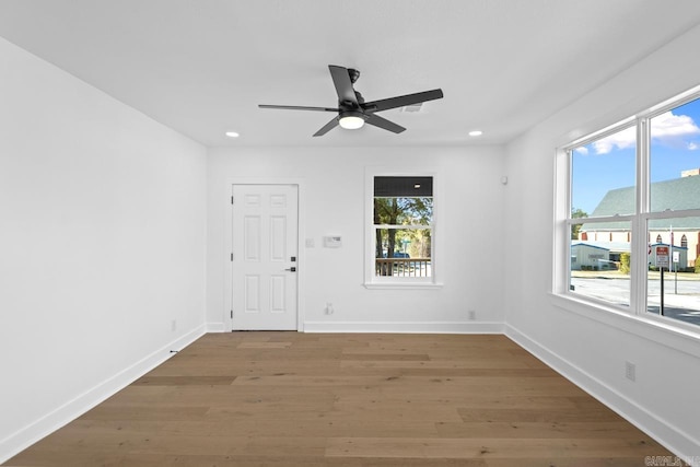 empty room with ceiling fan and hardwood / wood-style flooring