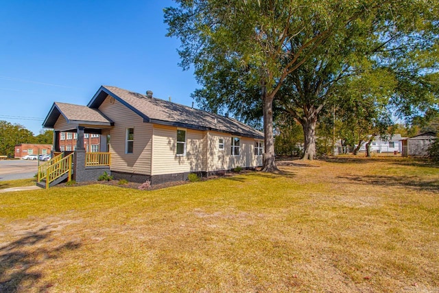 view of side of home with a yard