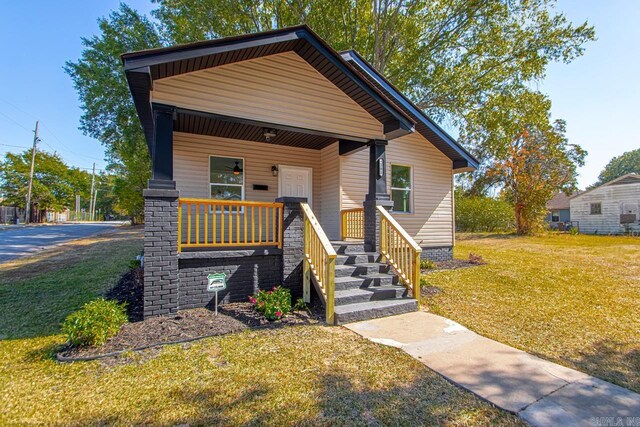 bungalow-style house featuring a front yard and covered porch