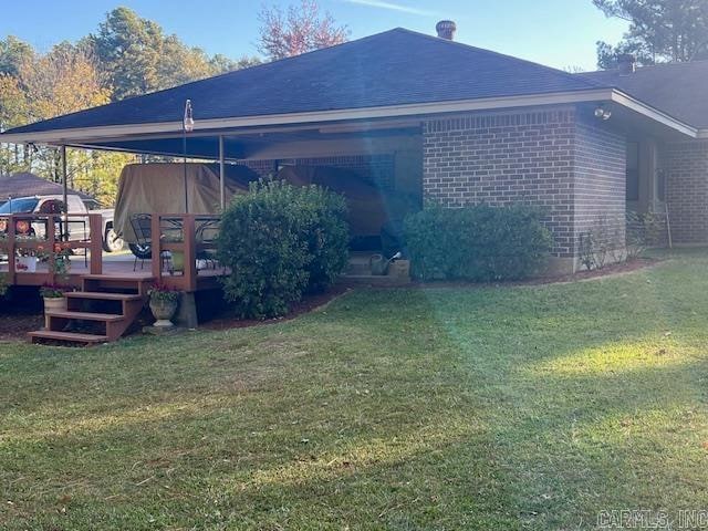 rear view of house with a deck and a yard