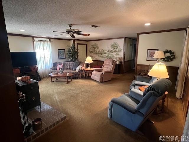 living room featuring ceiling fan, crown molding, a textured ceiling, and carpet flooring