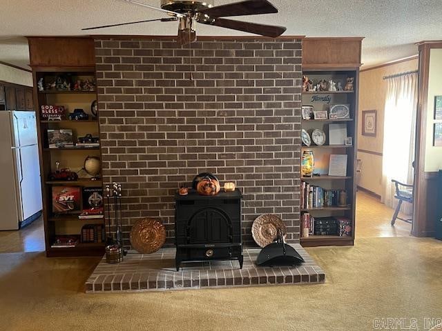 carpeted living room with a textured ceiling, a wood stove, and ceiling fan