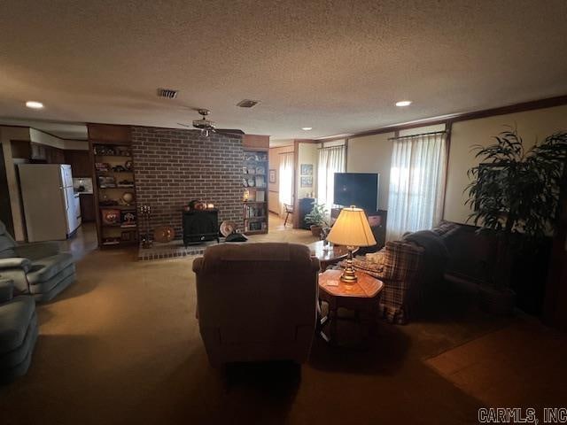 carpeted living room with ceiling fan, crown molding, a textured ceiling, and a wood stove