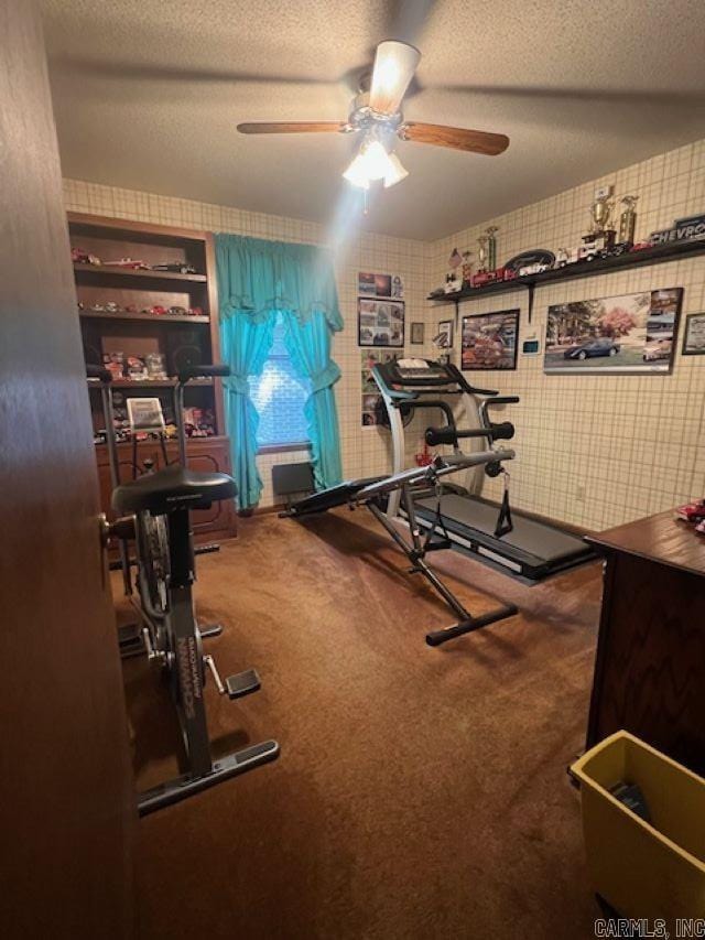 workout area featuring a textured ceiling, carpet flooring, and ceiling fan