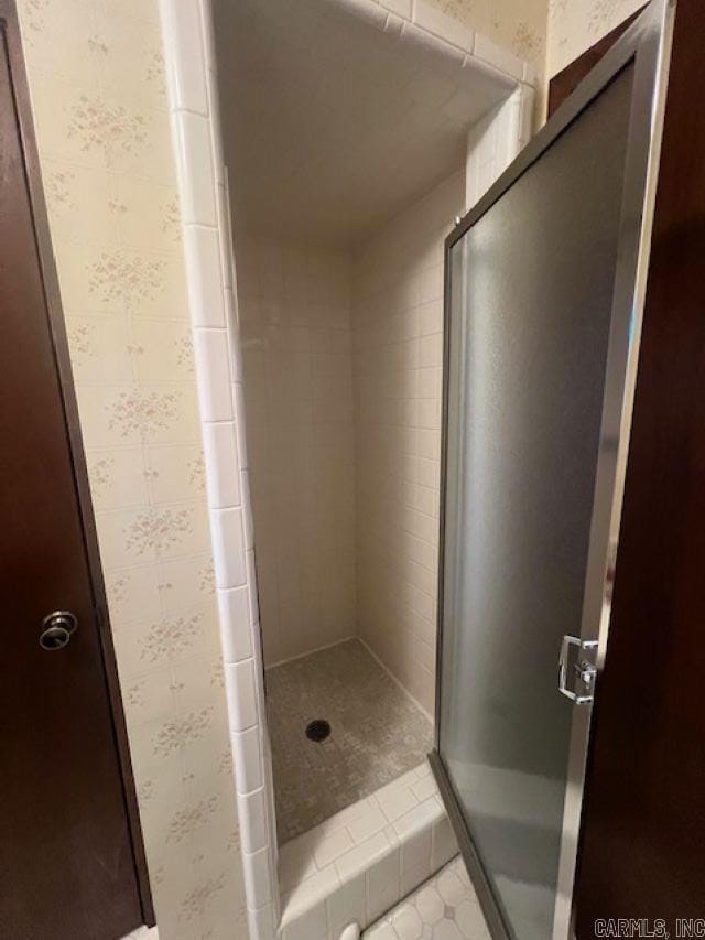 bathroom with a shower with shower door and tile patterned flooring