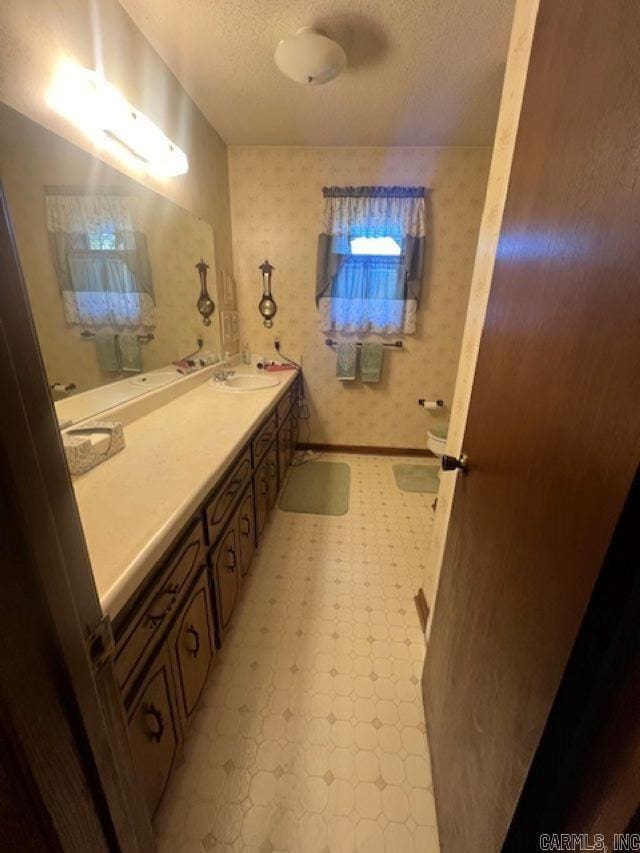 bathroom with a textured ceiling, tile patterned floors, and vanity