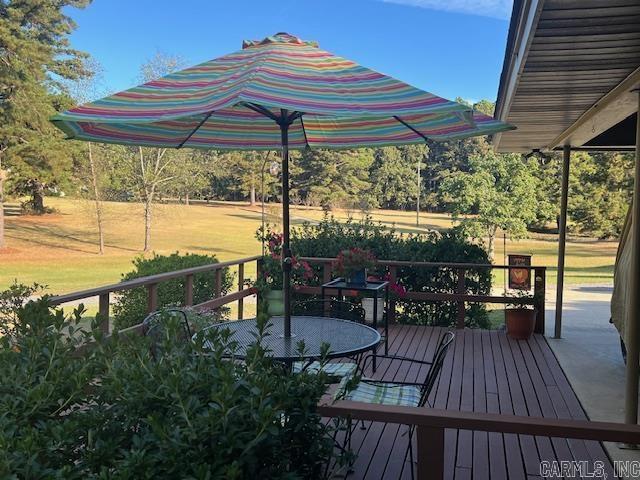 deck featuring outdoor dining area and a yard