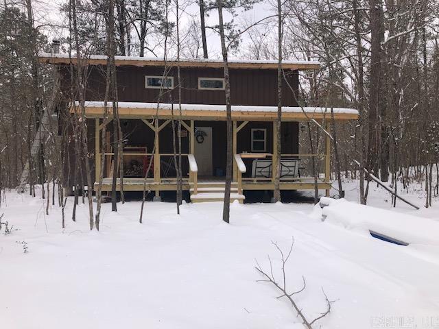 view of snow covered back of property