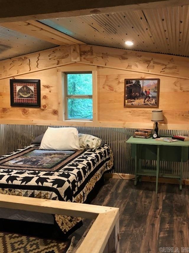 bedroom with wooden walls, wooden ceiling, and dark hardwood / wood-style flooring