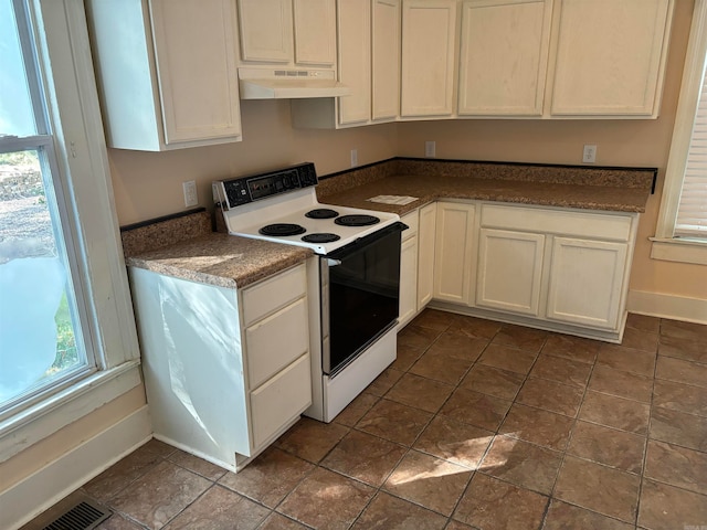 kitchen featuring white range with electric stovetop, white cabinets, and a healthy amount of sunlight