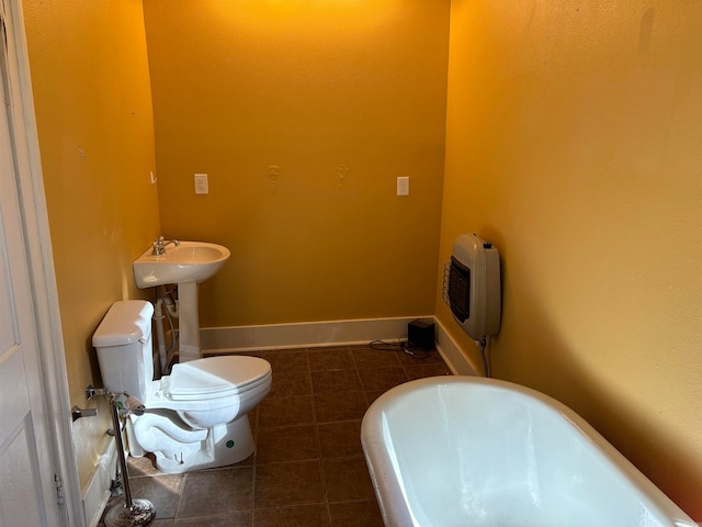 bathroom with sink, toilet, tile patterned floors, heating unit, and a bathing tub