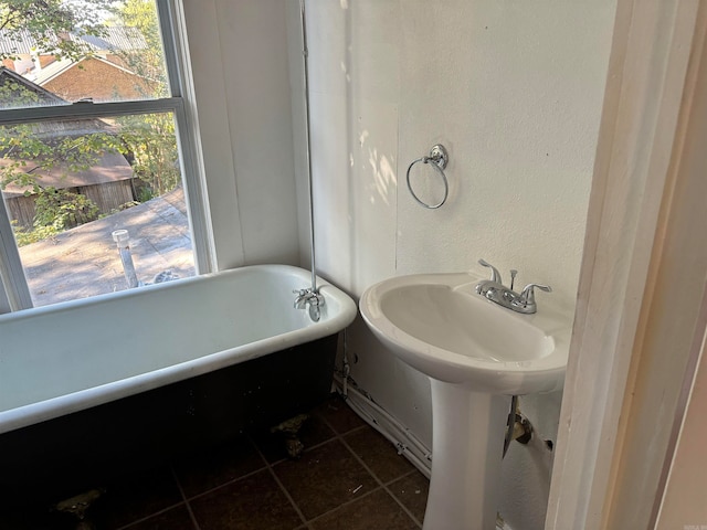 bathroom featuring tile patterned floors, a wealth of natural light, and a bathing tub