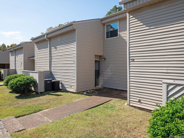 view of property exterior featuring central AC and a lawn