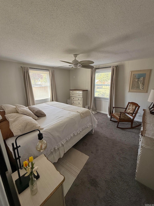 carpeted bedroom with ceiling fan and a textured ceiling