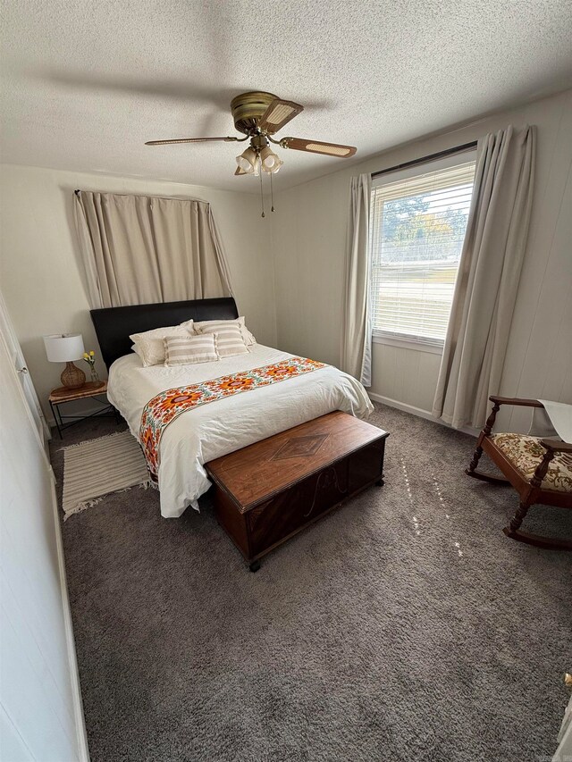 bedroom with ceiling fan, carpet flooring, and a textured ceiling