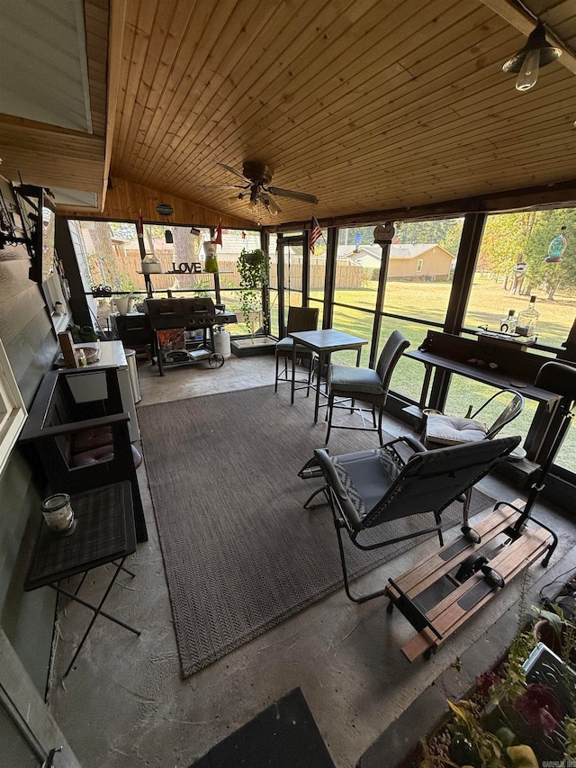 sunroom with vaulted ceiling, wood ceiling, and ceiling fan