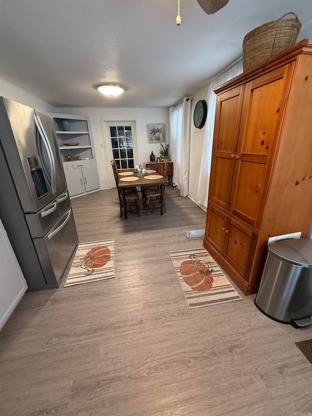 dining space with a textured ceiling and light wood-type flooring