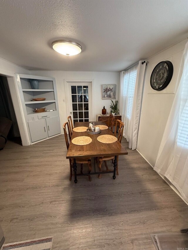 dining area featuring a textured ceiling and hardwood / wood-style flooring