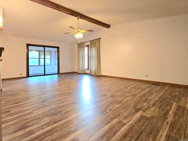 spare room with dark wood-type flooring, ceiling fan, lofted ceiling with beams, and a textured ceiling